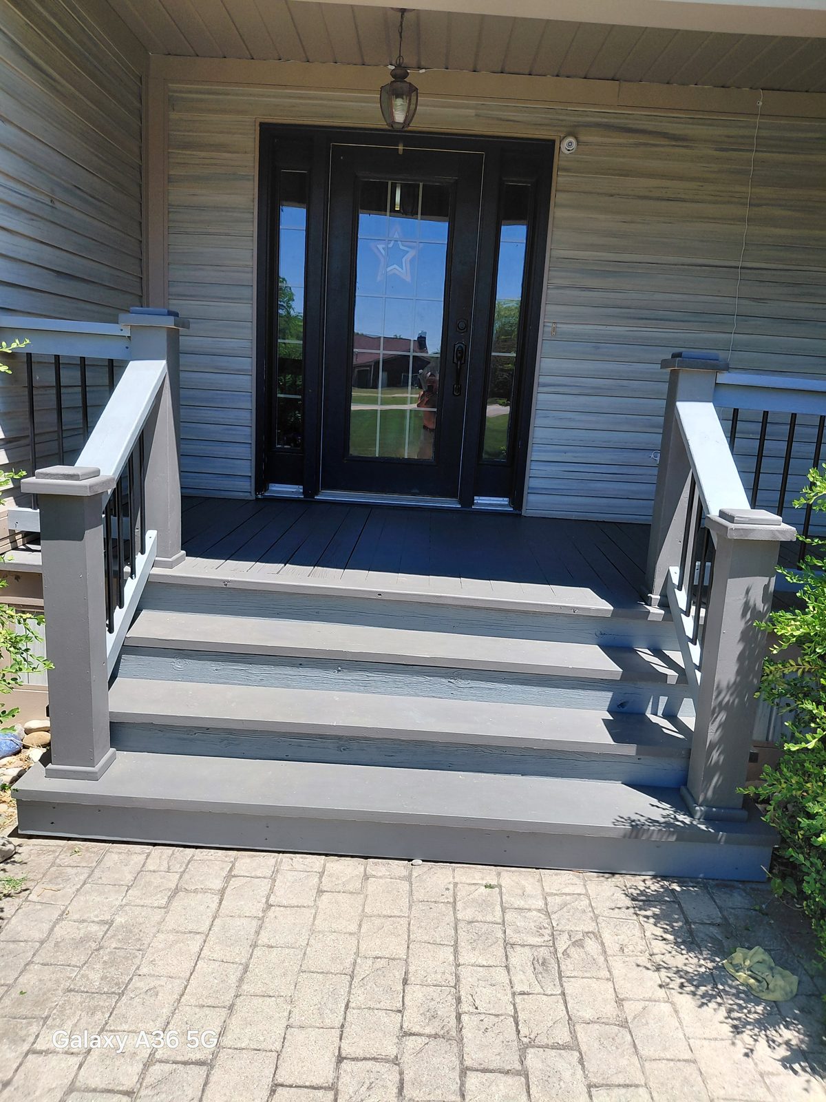 Front porch steps refinished in a fresh gray with black balusters