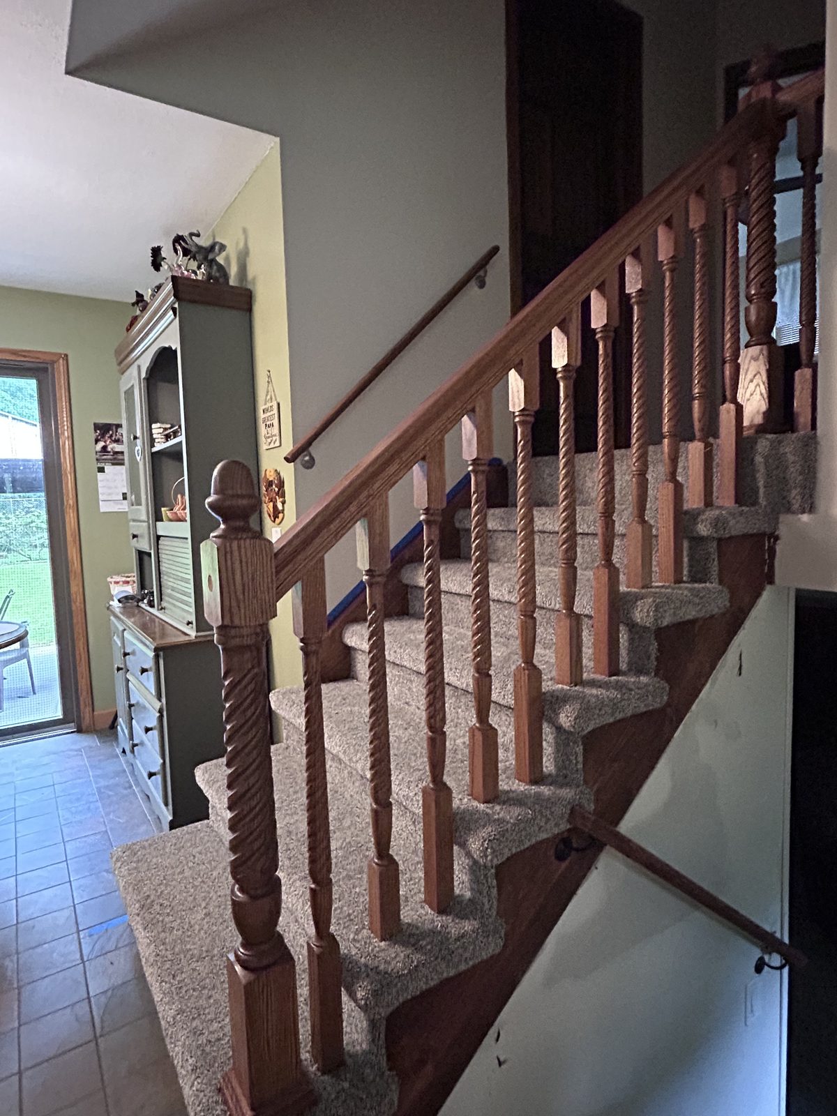 Completed interior staircase with a refinished oak railing and new carpet runner