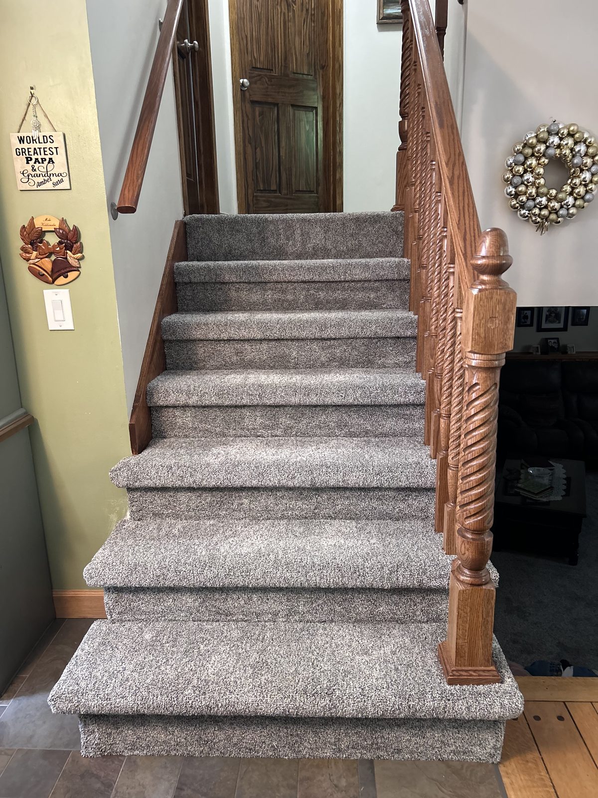 Finished staircase viewed head-on, with new carpet runner and refinished oak railing